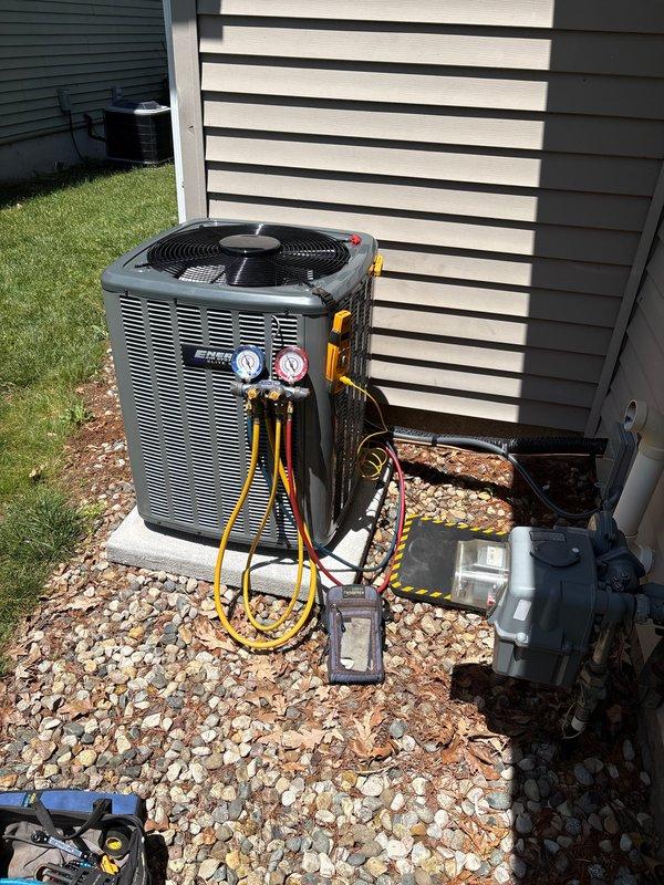 Completed full air conditioning system replacement including outdoor condensing unit and indoor air handler components. Removed existing equipment and installed new gray condensing unit on existing concrete pad with proper refrigerant line connections. Installed new indoor air handler in basement utility area adjacent to existing furnace and water heater. Ran new refrigerant lines with proper insulation, connected and secured all ductwork transitions using flexible and rigid metal ducting. Performed system startup procedures including refrigerant charge verification using manifold gauges, confirmed proper pressures on both high and low sides, tested electrical connections at disconnect box, and verified all safety controls. System tested and operating within manufacturer specifications with proper airflow and temperature differential across coil.