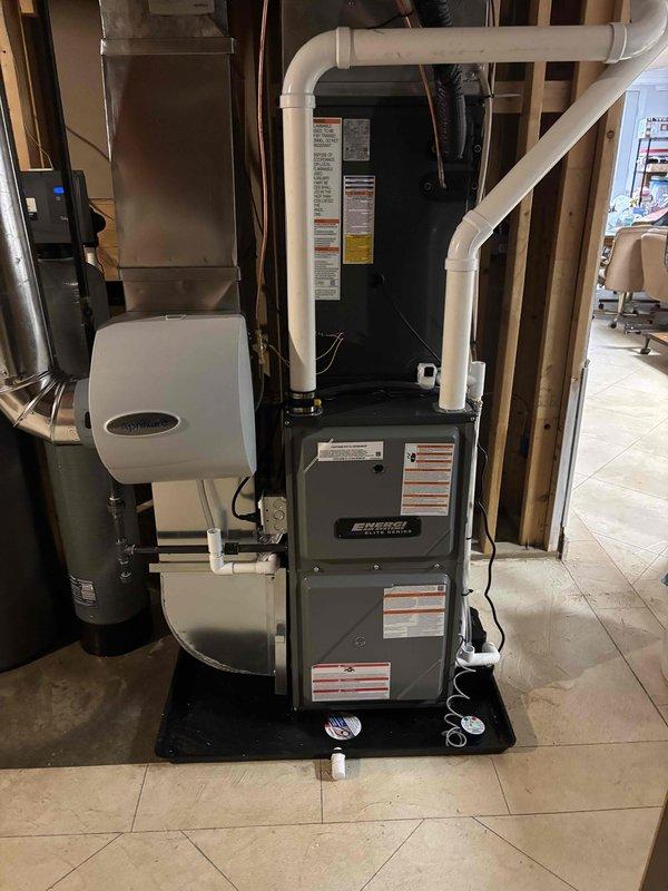 Completed full HVAC system installation including indoor furnace unit with integrated Aprilaire humidifier and outdoor air conditioning condenser. Installed all refrigerant line sets, electrical connections with exterior disconnect box, and complete white PVC condensate drain and venting system throughout basement utility area. Mounted outdoor condenser unit on concrete pad with proper clearances, verified all electrical connections, tested system operation, and ensured proper drainage routing for both heating and cooling components.