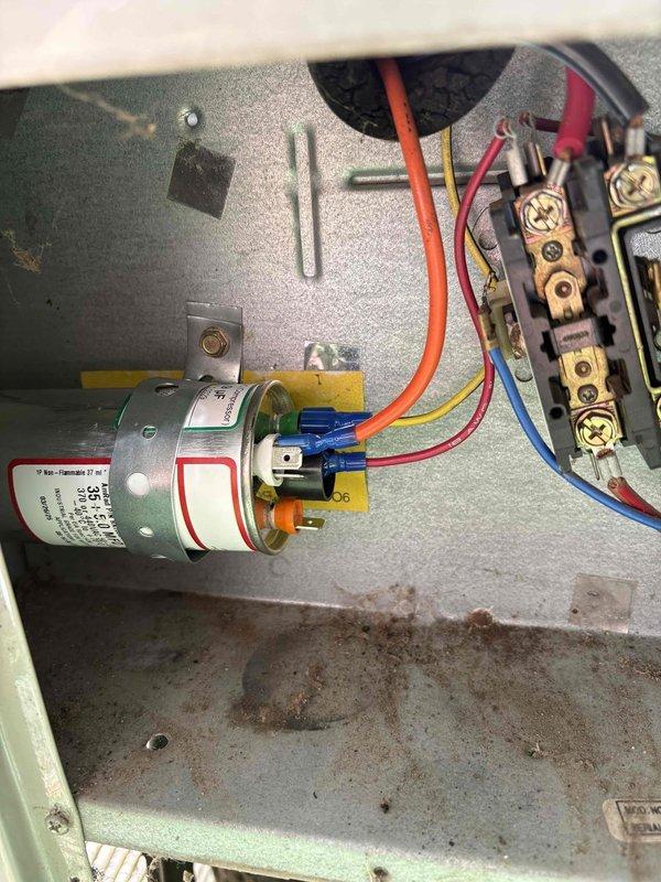 Responded to cooling system low refrigerant call on 29-year-old Trane unit. Upon inspection, accessed outdoor condensing unit and electrical control panel to assess system condition. Found unit operating with insufficient refrigerant charge as reported. Observed aging components including capacitor with proper wire connections and contactor assembly, though control panel interior showed rust staining and moisture exposure consistent with unit age. Evaporator coil exhibited dust and debris accumulation on fins. Recharged system with appropriate refrigerant to manufacturer specifications and verified proper operation. Unit restored to normal cooling function.