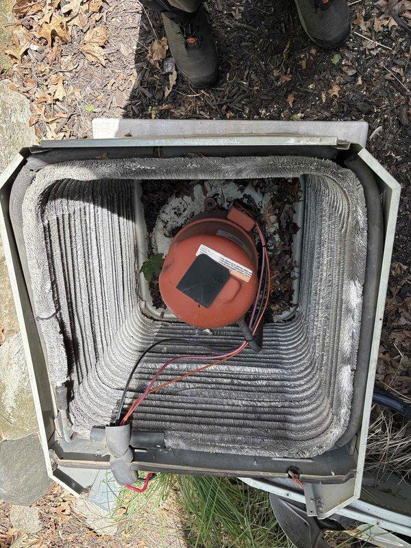 Responded to cooling system low refrigerant call on 29-year-old Trane unit. Upon inspection, accessed outdoor condensing unit and electrical control panel to assess system condition. Found unit operating with insufficient refrigerant charge as reported. Observed aging components including capacitor with proper wire connections and contactor assembly, though control panel interior showed rust staining and moisture exposure consistent with unit age. Evaporator coil exhibited dust and debris accumulation on fins. Recharged system with appropriate refrigerant to manufacturer specifications and verified proper operation. Unit restored to normal cooling function.