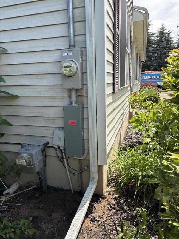 Completed 200-amp electrical service upgrade including coordination with utility company for temporary power disconnect and reconnect. Installed new electrical panel with circuit breakers in basement utility area, upgraded exterior meter base and service entrance conductors with proper conduit installation on exterior wall. Obtained electrical permit PE26-0124 and coordinated required inspection. All work performed to current NEC standards with power successfully restored following completion.