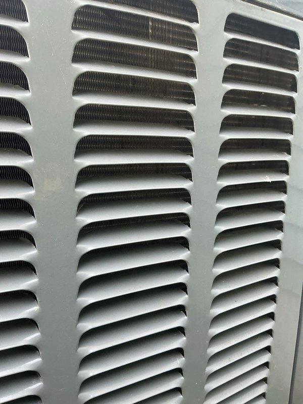 Completed annual cooling maintenance on EnergiAir system with 2-year warranty coverage expiring June 2033. Inspected outdoor condenser unit including coil louvers and ventilation grilles, which showed accumulated dirt, dust, and weathering consistent with outdoor exposure. Documented equipment condition through photographs showing exterior louvers with brownish discoloration on slats and internal heat exchanger components visible through grille openings, indicating need for routine cleaning during future service intervals.