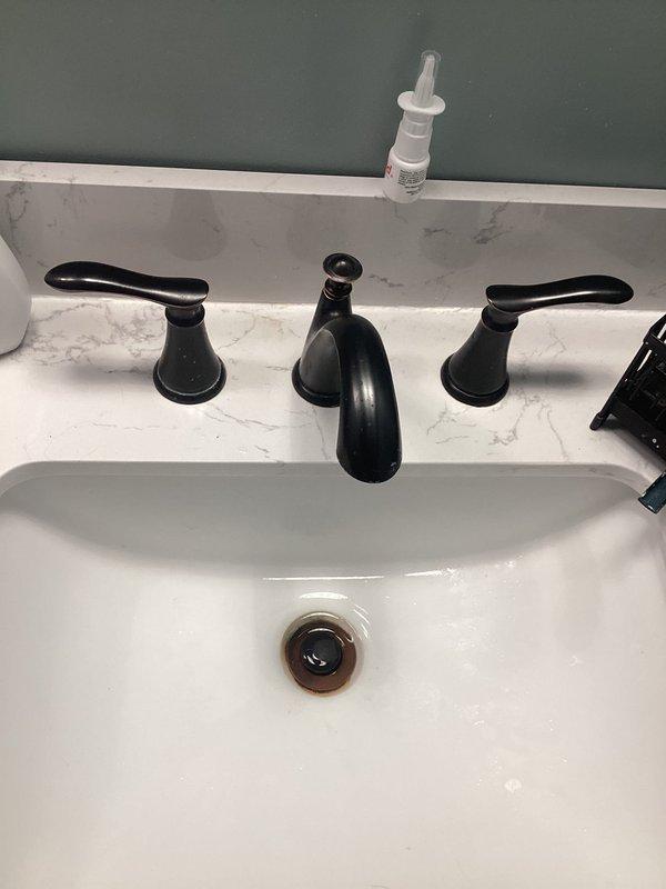 Responded to bathroom faucet leak and slow-draining sink in 161-year-old home. Inspected widespread three-handle faucet configuration with oil-rubbed bronze finish and undermount porcelain basin. Identified leak source at faucet connection points and addressed drainage issue affecting bathroom sink for approximately one month. Performed necessary repairs to restore proper function to both faucet and drain system, ensuring no water leakage and improved drainage flow. Verified repairs and confirmed issue was isolated to bathroom only with no other plumbing concerns throughout the home.