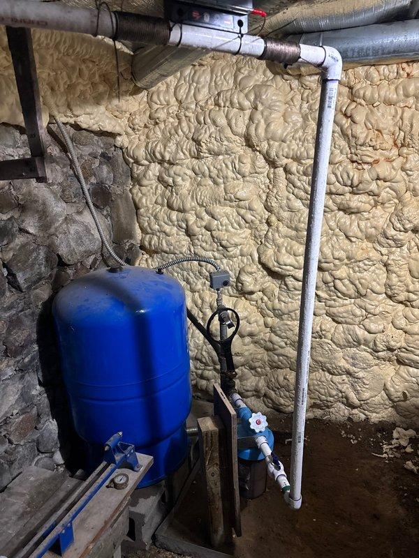 Conducted on-site assessment for whole house water filtration and conditioning system installation in a 126-year-old home with 28-year-old plumbing updates. Inspected existing basement infrastructure including current well pressure tank system, stone foundation walls, and available utility space to determine optimal equipment placement and integration points. Evaluated existing plumbing configuration with visible PVC distribution lines, spray foam insulated walls, and concrete floor conditions to develop comprehensive installation plan for requested water treatment system upgrade.
