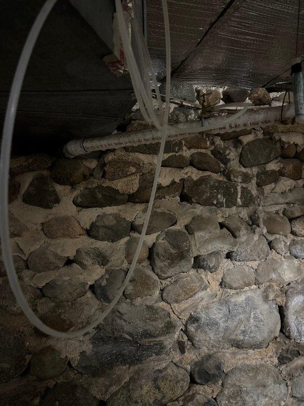 Conducted on-site assessment for whole house water filtration and conditioning system installation in a 126-year-old home with 28-year-old plumbing updates. Inspected existing basement infrastructure including current well pressure tank system, stone foundation walls, and available utility space to determine optimal equipment placement and integration points. Evaluated existing plumbing configuration with visible PVC distribution lines, spray foam insulated walls, and concrete floor conditions to develop comprehensive installation plan for requested water treatment system upgrade.