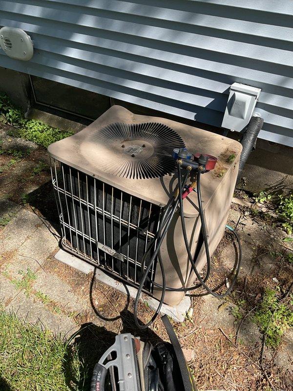 # NC-No Cool Service Call

Responded to no cooling complaint on 1998 Lennox air conditioning system that displayed "cool" mode but failed to produce conditioned air. Upon arrival, performed visual inspection of outdoor condenser unit, which showed significant age-related deterioration including surface rust, discoloration, and accumulated dirt and debris on top panel and fan assembly. Documented existing conditions with photographs showing weathered cabinet, refrigerant line connections, electrical conduit, PVC condensate drain, and overall installation setup on deteriorated concrete pad with vegetation growth.

Given the 27-year age of the equipment and the system's failure to cool despite thermostat indicating cooling mode, conducted diagnostic assessment of the outdoor unit. The condenser showed clear signs of extended outdoor exposure and minimal maintenance over its service life. Refrigerant lines, electrical connections, and drainage components were visually inspected and photogr