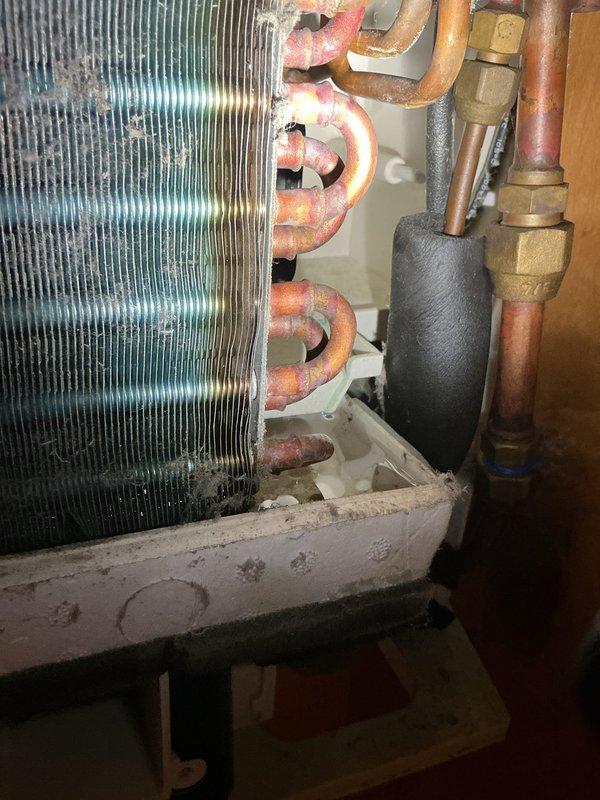 Responded to water leak complaint on 8-year-old Bryant AC unit in bedroom. Upon inspection, found evaporator coil and refrigerant lines showing significant corrosion and oxidation, with condensate drain system plugged as customer suspected. Cleared blocked drain line, inspected drain pan for proper drainage, and verified condensate removal system functioning correctly to resolve water leakage issue.