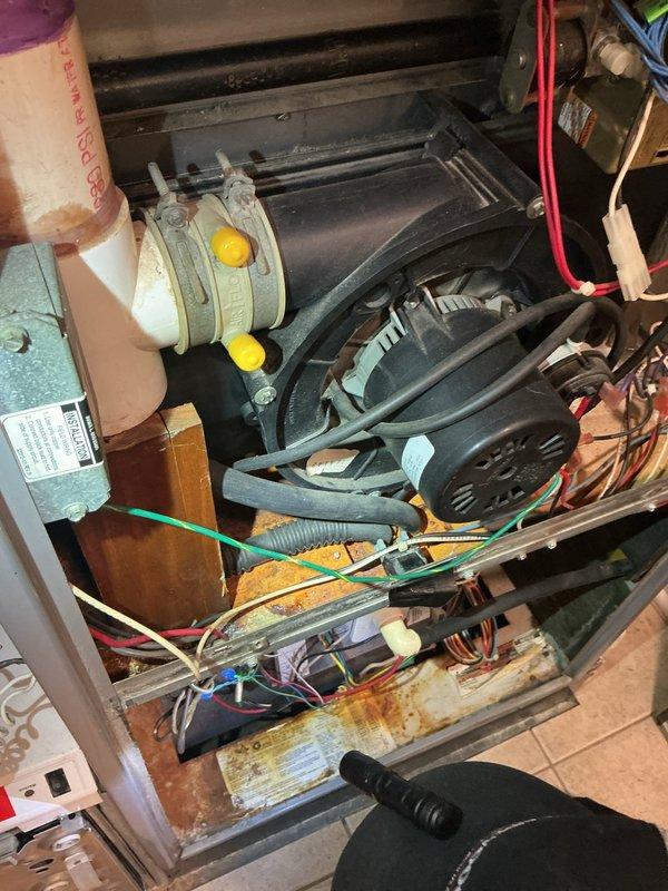 Completed comprehensive AC Super Tune-up on residential system, performing detailed inspection of all mechanical and electrical components within the air handler compartment. Observed evidence of moisture exposure with rust discoloration on the condensate drain pan, noted system age showing general wear on internal components, and verified all electrical connections, refrigerant lines, and motor assembly were functioning properly with no immediate service needs identified.