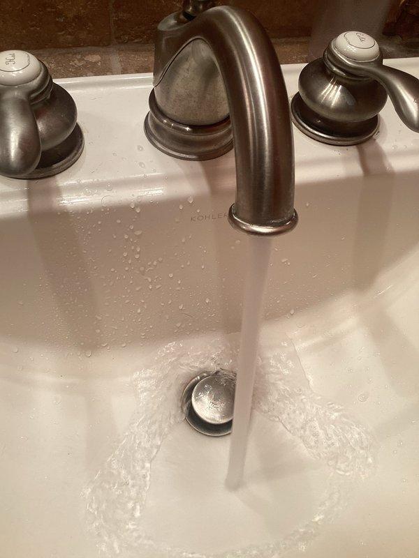Returned to address faucet aerator issue on Kohler Fairfax widespread lavatory faucet. Upon inspection, determined that the spout lacks the standard threaded groove connections required for aerator installation. Referenced Kohler service parts diagram to verify proper replacement component needed. Will schedule follow-up visit to install correct spout assembly with appropriate aerator threading.