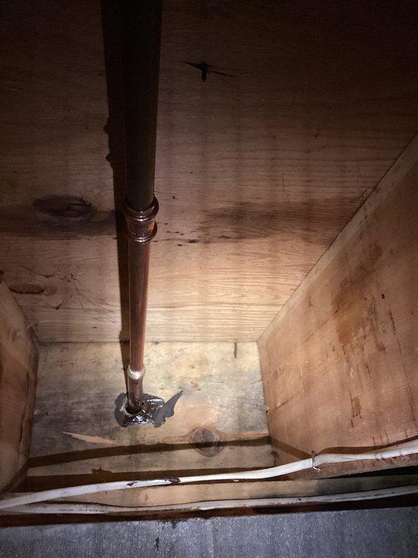 Responded to no-water complaint affecting both exterior hose spigot and interior shower fixture. Upon inspection, identified copper supply line issue within vertical plumbing chase between floors. Assessed bathroom fixtures including tub/shower valve assembly and traced water supply through wall cavity to determine source of service interruption. Documented existing tile conditions showing moisture-related deterioration and verified fixture mounting hardware. Examined copper piping run secured with metal brackets through wooden chase structure to locate supply problem. Restored water service to both affected fixtures.