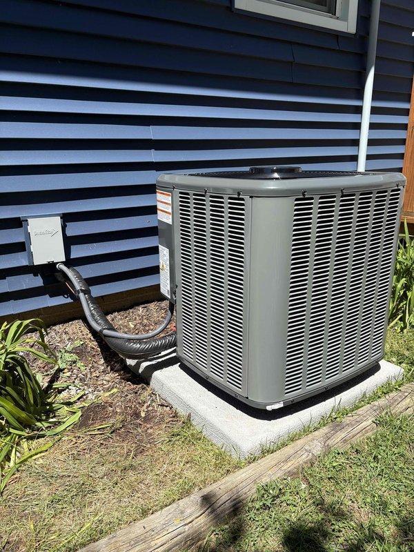 Completed full air conditioning system replacement at residential property. Removed existing outdoor condensing unit and installed new replacement unit on existing concrete pad with proper refrigerant line connections and electrical disconnect. Unit positioned alongside house exterior with adequate clearance for airflow and serviceability. Indoor air handler integrated with existing Amana furnace system in basement mechanical room, utilizing existing ductwork infrastructure. All refrigerant lines properly insulated and secured, electrical connections completed to code, and system tested for proper operation including temperature differential and refrigerant charge verification. Installation completed as same-day service.