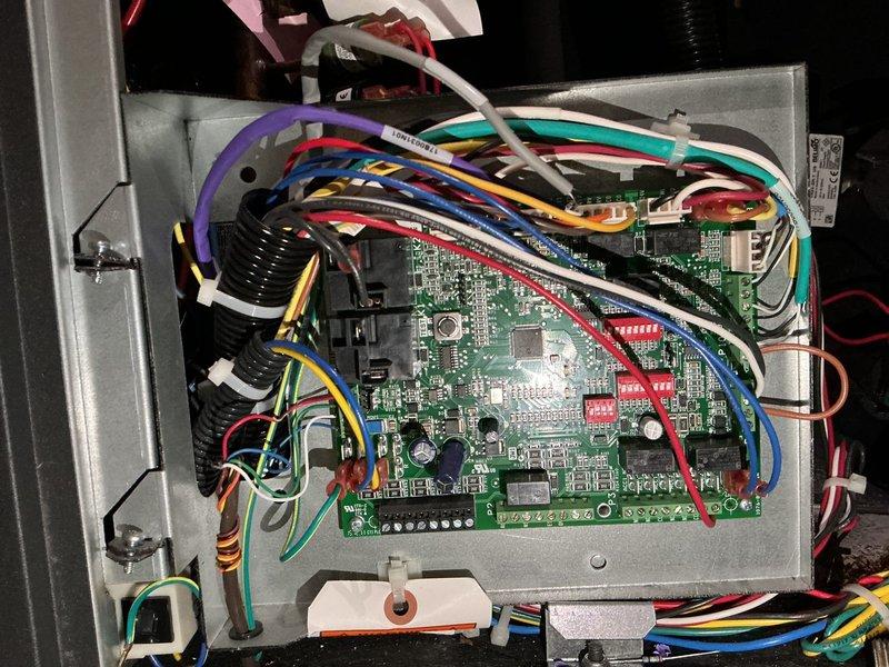 Responded to air conditioning unit displaying E5 error code indicating low air coil temperature. Upon arrival, accessed control board housing and performed diagnostic inspection of electronic control system and associated wiring connections. Inspected circuit board for fault conditions, verified proper electrical connections to temperature sensors, and examined control panel components including integrated circuits and relay switches. Evaluated refrigerant line connections and coil temperature sensor operation. Documented control board configuration and wiring harness condition through photographic records. System operational at time of inspection with no immediate loss of cooling reported. Provided findings and recommendations for monitoring unit performance.