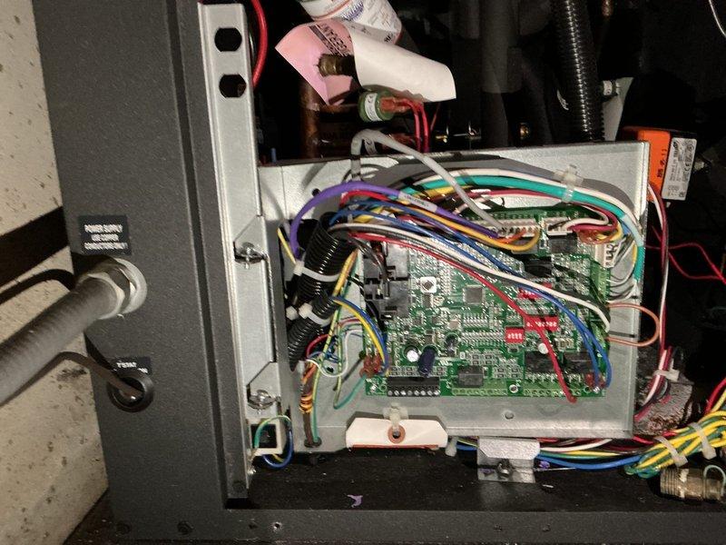 Responded to air conditioning unit displaying E5 error code indicating low air coil temperature. Upon arrival, accessed control board housing and performed diagnostic inspection of electronic control system and associated wiring connections. Inspected circuit board for fault conditions, verified proper electrical connections to temperature sensors, and examined control panel components including integrated circuits and relay switches. Evaluated refrigerant line connections and coil temperature sensor operation. Documented control board configuration and wiring harness condition through photographic records. System operational at time of inspection with no immediate loss of cooling reported. Provided findings and recommendations for monitoring unit performance.