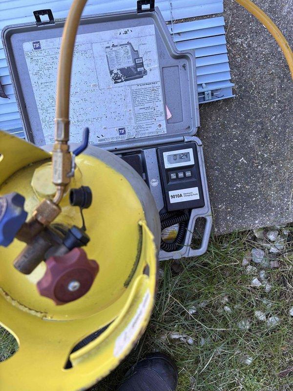 Responded to service call for 9-year-old mini-split system experiencing freeze-over conditions and water leakage. Unit was ejecting ice from front discharge, though condensate line had been previously cleared and was draining properly. Diagnosed low refrigerant charge as root cause of evaporator coil icing. Performed system evacuation using vacuum pump, then recharged system to manufacturer specifications using calibrated refrigerant scale. Verified proper operating pressures on gauge manifold and confirmed system returned to normal operation without ice formation.