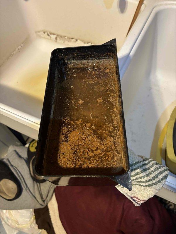 Completed comprehensive AC Super Tune-up on 12-year-old system. During inspection, discovered significant rust-colored sediment and debris accumulation in condensate drain pan, indicating long-term buildup and potential drainage issues. Cleaned and flushed drain pan, removed accumulated sediment, and verified proper condensate drainage to prevent future overflow and water damage.