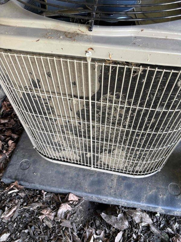 # CP-Cooling Problem Resolution

Responded to service call for 16-year-old air conditioning system running but not producing cold air. Upon arrival, performed visual inspection of outdoor condenser unit, which showed significant weathering, accumulated debris, and grime buildup on protective grille and coil surfaces. Documented existing condition with photographs.

During inspection, discovered evidence of previous electrical fire damage at wall penetration point where refrigerant lines and electrical conduit enter structure. Burn damage was extensive with charred wood framing and damaged insulation visible around opening. This fire damage likely compromised electrical connections and/or refrigerant line integrity, resulting in system malfunction and loss of cooling capacity.

Advised customer of fire damage findings and potential safety concerns. Recommended immediate electrical inspection and complete system evaluation to determine extent of damage to refrigerant lines, electrical wi