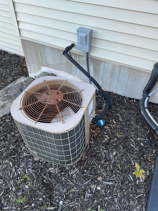 Conducted furnace replacement estimate for residential property with 22-year-old existing heating system located in attic space. Inspected current HVAC equipment installation, documented unit condition and configuration, photographed existing furnace with visible manufacturer specifications and warning labels, assessed attic accessibility and structural clearances for potential replacement unit, and evaluated electrical connections and ductwork routing. Exterior air conditioning condenser unit also documented during site assessment.