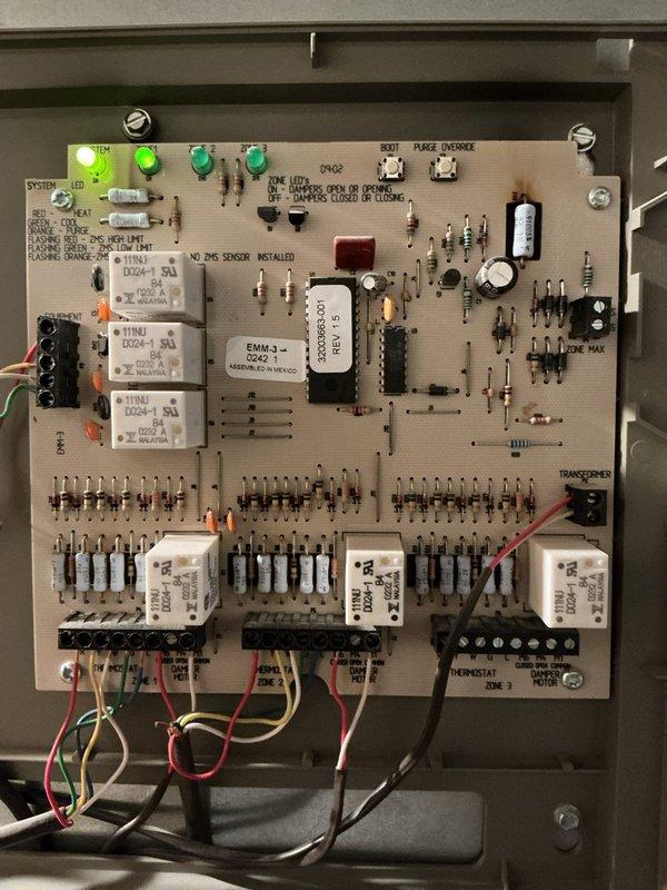 Responded to service call for cooling system not producing adequately cold air. Upon inspection, evaluated HVAC control board and zone control components. Inspected electronic control circuit board within main enclosure, verifying relay operation, LED indicators, and thermostat zone connections. Examined Honeywell damper actuator and associated refrigerant lines for proper function. Documented system configuration with photos of control board showing multiple relays, EMM-3 module, and zone control wiring, as well as damper actuator mounted on plenum with copper refrigerant lines. System assessed and necessary findings recorded for cooling performance issue.