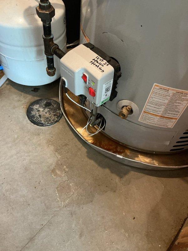 # Water Heater Replacement Due to Leaking Unit

Responded to service call for leaking water heater. Upon arrival, inspected 4-year-old Bradford White unit and confirmed active leak at base of tank. Observed significant rust discoloration in drip pan and water staining on concrete floor, indicating prolonged moisture exposure. Determined tank integrity was compromised and replacement was necessary.

Removed existing failed water heater and properly disposed of unit per local regulations. Installed new Bradford White water heater with appropriate venting and safety controls. Connected hot and cold water supply lines using copper piping and PEX tubing with secure fittings. Installed temperature and pressure relief valve with proper discharge piping. Mounted recirculation pump on top of unit and connected to plumbing system using blue PEX tubing secured with plastic clips to wall studs.

Verified all connections for proper sealing and tested system for leaks. Filled tank, purged air from l