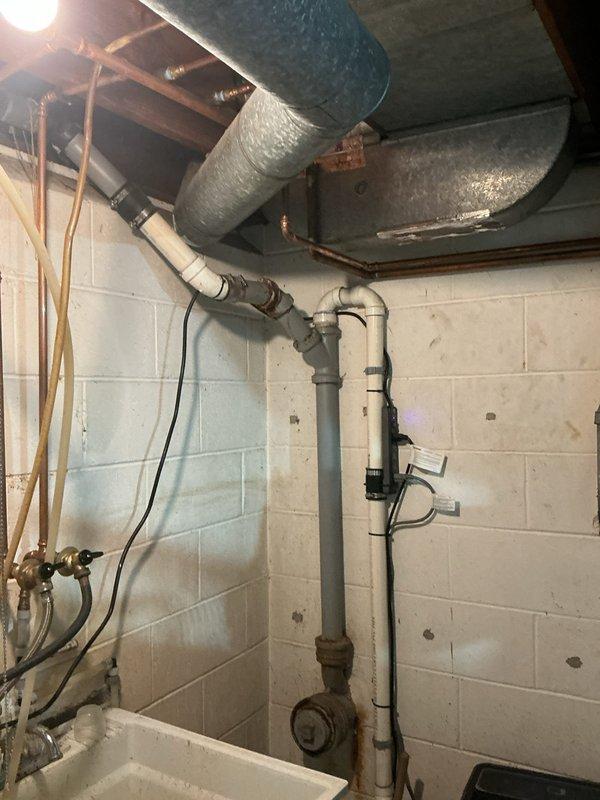 Responded to reported leak in toilet supply line. Upon inspection, accessed ceiling cavity and basement utility area to trace plumbing lines. Evaluated existing PVC drainage system, copper supply lines, and associated connections throughout the affected zones. Identified and assessed condition of pipes running through ceiling joists and vertical supply runs. Completed diagnostic inspection of plumbing infrastructure including shut-off valves and pipe joints in mechanical room area. Documented findings with photographic evidence showing accessible plumbing components and structural routing of water supply and drainage systems.