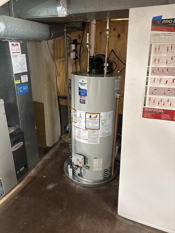 Completed installation of a 50-gallon Bradford White power vent natural gas water heater in utility room. Unit was properly connected with copper piping, brass fittings, and power vent exhaust system, with all manufacturer specifications and safety clearances met per code requirements.