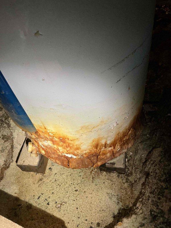 Responded to request for water heater replacement estimate. Inspected existing water heater unit located in crawl space. Unit age unknown but confirmed to be at least 6 years old based on available information. Documented significant rust and corrosion present at base of tank with orange-brown staining extending upward from bottom seam, indicating moisture exposure and deterioration. Observed water damage and discoloration on concrete floor surrounding unit. Photographed equipment labels, serial information, and extent of corrosion damage for estimate preparation. Provided replacement options for new water heater installation.