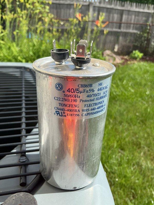 Responded to no cooling call on five-year-old residential air conditioning system affecting entire home. Upon inspection, diagnosed failed dual-run capacitor (40/5 μF, 440VAC) serving compressor and condenser fan motor. Removed defective TONGFENG ELECTRONICS capacitor and installed replacement unit with matching specifications. Verified proper electrical connections, tested system operation, and confirmed cooling restored to all areas of home. Unit returned to normal operation with proper amperage readings and temperature differential.