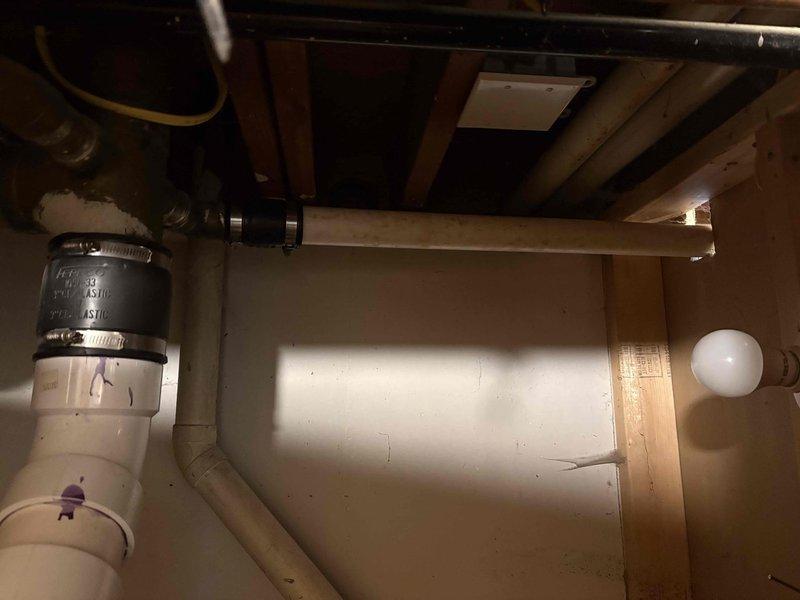 Responded to kitchen sink leak causing water intrusion into basement area. Upon inspection, identified failed P-trap assembly under kitchen sink as source of leak. Removed deteriorated plastic drain trap showing visible discoloration and wear. Installed new PVC P-trap assembly with proper rubber couplings and secured connections using metal hose clamps to ensure watertight seal. Tested drainage system to verify leak resolution and proper water flow. Work area cleaned and plumbing restored to full operation.