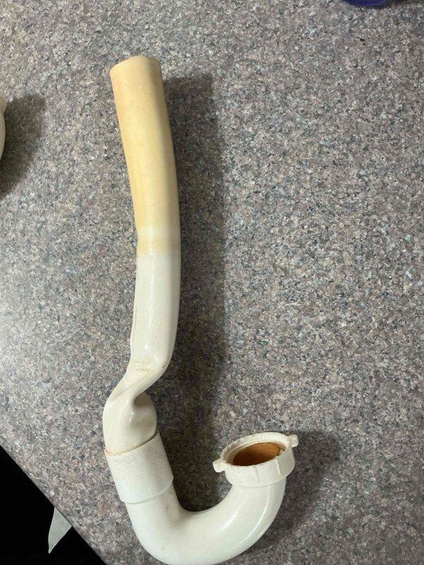 Responded to kitchen sink leak causing water intrusion into basement area. Upon inspection, identified failed P-trap assembly under kitchen sink as source of leak. Removed deteriorated plastic drain trap showing visible discoloration and wear. Installed new PVC P-trap assembly with proper rubber couplings and secured connections using metal hose clamps to ensure watertight seal. Tested drainage system to verify leak resolution and proper water flow. Work area cleaned and plumbing restored to full operation.