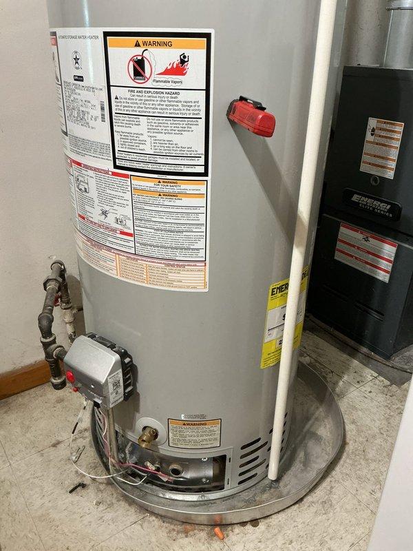Responded to no hot water complaint on 12-year-old Bradford White water heater affecting entire home. Upon inspection, examined electrical connections and components at base of unit, including wiring terminals and control systems. Assessed water heater condition, verified age and model specifications, and documented equipment status with detailed photographs of electrical connections, plumbing fittings, safety labels, and overall installation. Evaluated brass water connections, copper piping, circulation pump assembly, and emergency shutoff valve. Customer provided contact information for follow-up communication regarding findings and recommendations.