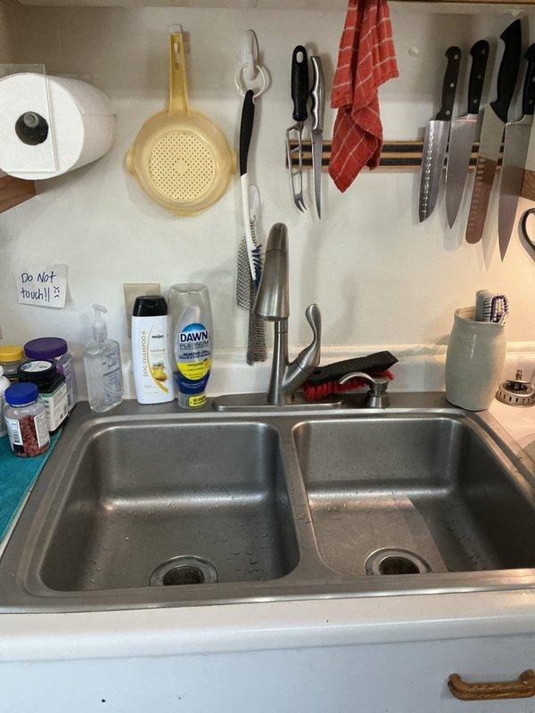 Responded to service call for multiple plumbing issues in a 1979-built residence, including four leaking faucets and one malfunctioning drain. Inspected bathroom sink with wall-mounted faucet assembly and kitchen double-basin stainless steel sink with pull-down sprayer. Addressed long-standing leak conditions, with the oldest leak having persisted for approximately ten years. Performed necessary repairs to restore proper function to all affected fixtures, eliminating water waste and preventing further damage. Documented conditions with photographs for service records.