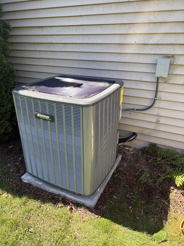 Completed full HVAC system replacement including outdoor condensing unit and indoor air handler. Removed existing equipment and installed new AC condenser on concrete pad with proper clearances from exterior wall. Mounted unit features louvered metal casing with top-mounted fan assembly. Secured refrigerant lines and electrical conduit to building exterior per code requirements. Indoor installation included new furnace unit with dual PVC venting system routed vertically through structure. Connected electrical service at junction panel and verified all wiring connections. System tested for proper operation, refrigerant charge confirmed, and airflow verified at all registers. Payment processed via credit card upon completion.