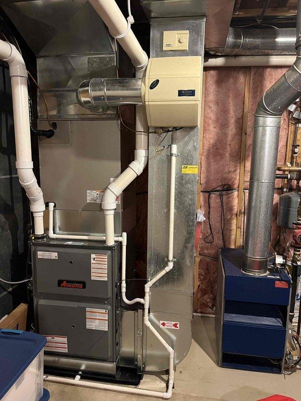 Completed annual cooling system maintenance and inspection on residential HVAC system consisting of Amana furnace with integrated cooling coil and outdoor condensing unit. Performed comprehensive tune-up including refrigerant charge verification, electrical connection inspection, condensate drain line check, and filter assessment. Inspected outdoor condenser unit positioned on concrete pad, verified proper airflow through louvers, and confirmed unit operation. Evaluated indoor mechanical room components including PVC condensate piping network, humidifier integration, and ductwork connections. All systems operating within normal parameters with no immediate service concerns identified.