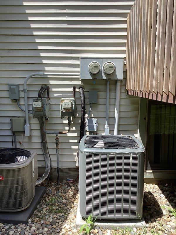 Completed comprehensive electrical club inspection of residential service equipment and outdoor HVAC electrical installations. Documented existing conditions of main electrical panel showing older-style wiring with multiple circuits, noted accumulated debris and age-related deterioration within panel enclosure. Inspected exterior electrical components including meter housings, service conduit, and disconnect equipment serving two air conditioning units. Photographed weathered metal conduit showing oxidation and overall electrical infrastructure condition for compliance documentation and future reference.