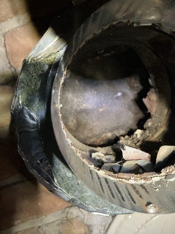 Responded to service call for non-functioning water heater with water present in drain pan. Upon inspection, found 10-year-old Bradford White water heater in basement utility area showing signs of failure. Discovered significant internal corrosion and deterioration of tank components, with rust-colored oxidation and moisture damage throughout the system. Observed accumulated debris and insulation fragments inside compromised components, indicating advanced deterioration and structural failure. Water heater had reached end of service life with tank integrity compromised, causing water leakage into catch pan. Documented conditions with photographs showing extent of corrosion and component failure for replacement recommendation.