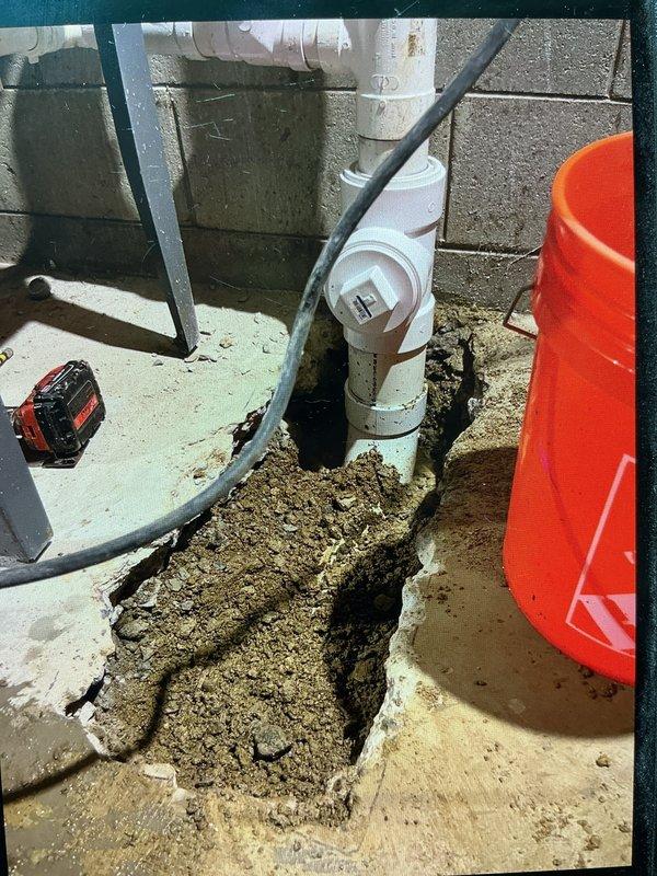 Replaced 3 feet of deteriorated cast iron drain pipe in an outdoor utility area. Excavated and removed failed section, tied in new PVC piping to existing underground drainage system, and rebuilt vertical drain stack above ground level using PVC components with proper fittings and transitions.
