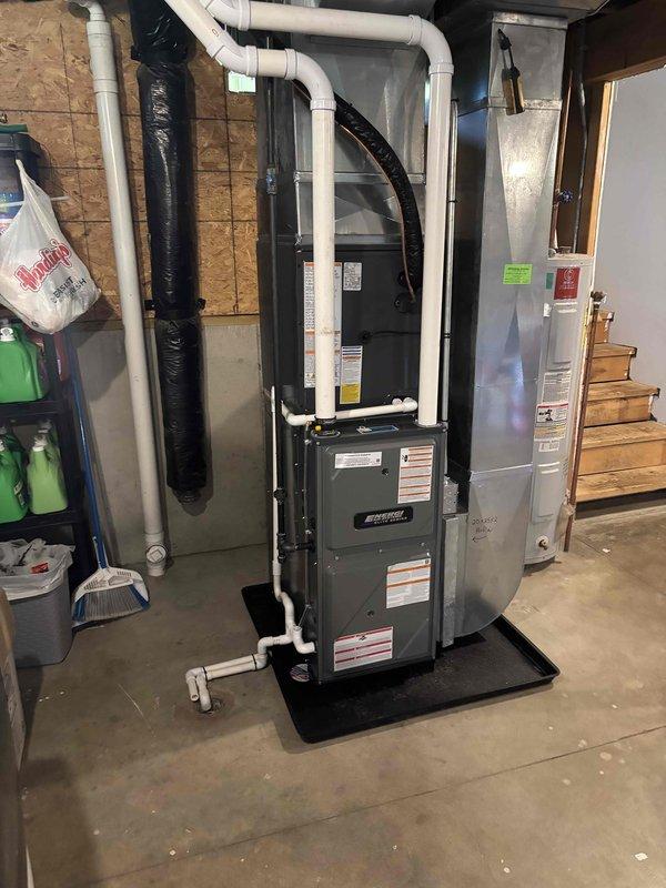Completed full HVAC system installation in residential basement, including new high-efficiency furnace and air conditioning system. Installed furnace unit on protective mat with proper clearances, connected white PVC venting and condensate drainage piping, and integrated black flexible supply ductwork to existing distribution system. Mounted metal supply plenum vertically for optimal airflow distribution. All electrical connections completed to code, gas piping verified for proper operation, and system commissioned with successful startup. Coordinated installation alongside existing water heater to maintain adequate service access. Michigan Saves financing documentation processed and submitted electronically for approval. All manufacturer specifications followed, safety labels verified, and unit tested for proper heating and cooling operation prior to customer handoff.