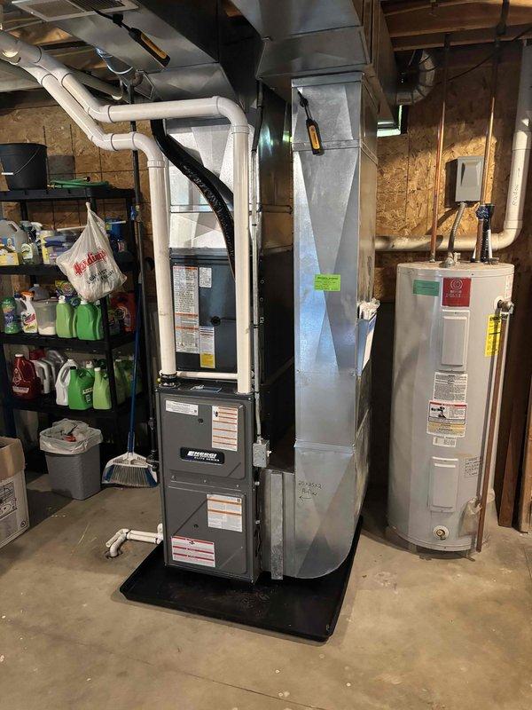 Completed full HVAC system installation in residential basement, including new high-efficiency furnace and air conditioning system. Installed furnace unit on protective mat with proper clearances, connected white PVC venting and condensate drainage piping, and integrated black flexible supply ductwork to existing distribution system. Mounted metal supply plenum vertically for optimal airflow distribution. All electrical connections completed to code, gas piping verified for proper operation, and system commissioned with successful startup. Coordinated installation alongside existing water heater to maintain adequate service access. Michigan Saves financing documentation processed and submitted electronically for approval. All manufacturer specifications followed, safety labels verified, and unit tested for proper heating and cooling operation prior to customer handoff.