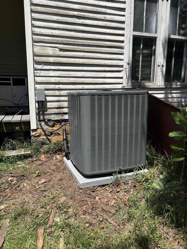 Completed full HVAC system installation including new furnace and air conditioning unit. Installed outdoor condensing unit on concrete pad with proper refrigerant line routing and electrical connections. Unit positioned against exterior wall with appropriate clearances for airflow and service access. Ran electrical conduit and wiring from disconnect box to equipment, ensuring code-compliant installation. System startup performed, all connections verified secure, and unit tested for proper operation.