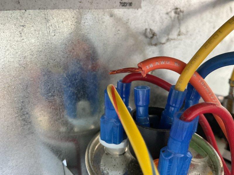 Completed annual cooling maintenance on two ICP air conditioning systems (19-year and 17-year units). During inspection, discovered active electrical hazard with smoking wire connections at low-voltage control circuit. Immediately de-energized system and addressed overheating wire nuts and compromised connections showing visible heat damage and discoloration on surrounding insulation. Replaced damaged wire connectors, re-terminated 18 AWG control wiring, and secured all electrical junctions per code. Verified proper wire gauge specifications and color coding throughout control circuit. Completed standard tune-up procedures on both units including filter inspection, coil cleaning, refrigerant charge verification, and operational testing. All systems restored to safe operating condition with no further electrical anomalies detected.
