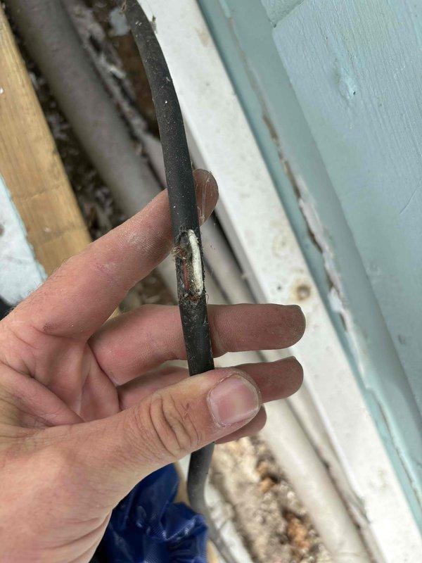 Responded to E1 communication error on 9-year-old MRCOOL mini-split system occurring when condenser attempted to engage for heating or cooling modes. Upon inspection, discovered severely damaged communication wiring between indoor and outdoor units with compromised insulation and exposed conductors. The deteriorated wire section showed extensive wear where protective jacketing had completely degraded, creating intermittent signal failure between components. Documented wire damage with photographs showing frayed insulation and exposed internal wiring that was causing the communication fault code.