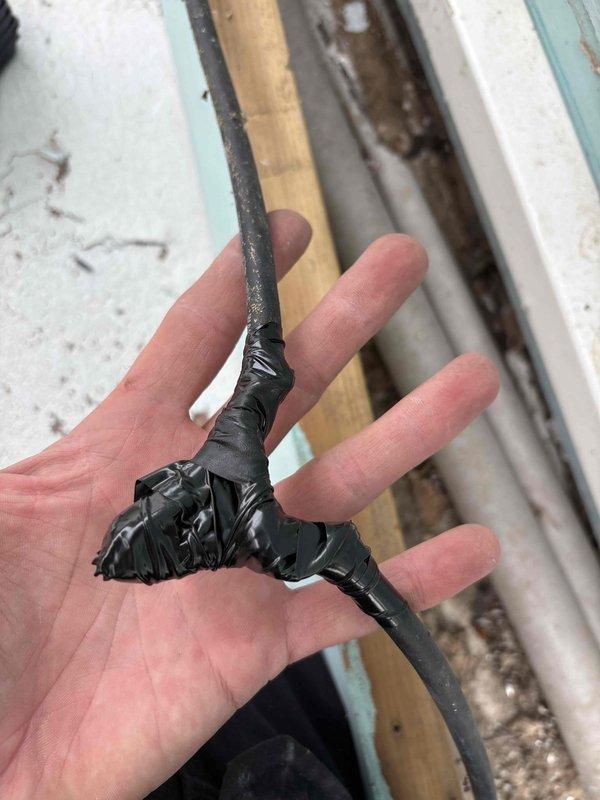 Responded to E1 communication error on 9-year-old MRCOOL mini-split system occurring when condenser attempted to engage for heating or cooling modes. Upon inspection, discovered severely damaged communication wiring between indoor and outdoor units with compromised insulation and exposed conductors. The deteriorated wire section showed extensive wear where protective jacketing had completely degraded, creating intermittent signal failure between components. Documented wire damage with photographs showing frayed insulation and exposed internal wiring that was causing the communication fault code.