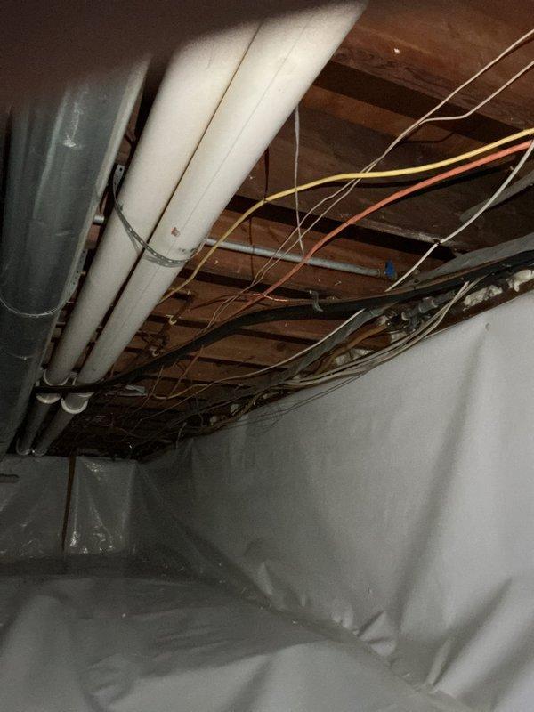 Performed site assessment of basement and crawl space to provide estimate for natural gas line installation to deck-mounted grill. Inspected existing utility infrastructure including plumbing, HVAC ductwork, and electrical systems routed through floor joists to determine optimal path for new gas line. Documented current conditions of crawl space including vapor barrier placement and clearances around existing PVC drainage systems and condensate pump assembly. Photographed routing options through exposed joists to exterior deck location for estimate preparation.