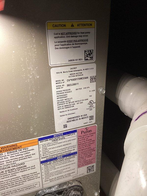# Central Air Conditioning System - No Cooling Condition

Responded to service call for 2-year-old central air conditioning system with complete loss of cooling capacity. Upon arrival, performed visual inspection of outdoor condensing unit and indoor air handler components.

Exterior unit examination revealed significant accumulation of organic debris (leaves and plant material) in electrical component compartment and condensate drain pan area. Debris had collected around capacitor and electrical connections, creating potential for component failure and compromised system operation.

Documented equipment specifications from air handler nameplate: Model CV=2VA30172MGE4AA, Serial 3222J36511, utilizing TXV metering device and appropriate refrigerant type. Verified unit design pressures (625 PSIG high side, 310 kPa specifications) for reference during diagnostic procedures.

Inspected electrical connections at outdoor unit capacitor, noting multiple wire terminations (yellow, red, blue, gr