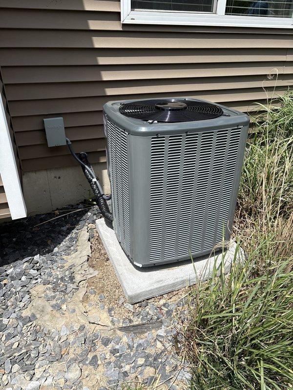 Completed full air conditioning system replacement including outdoor condenser unit and indoor air handler components. Installed new Trane equipment with proper refrigerant line connections, electrical conduit, condensate drainage via PVC piping, and integrated ductwork to existing furnace system. Mounted outdoor unit on concrete pad with gravel surround and verified all connections, airflow, and system operation per manufacturer specifications.