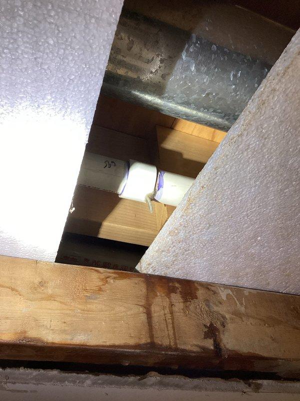 Responded to water leak in basement. Upon investigation, discovered active leak originating from plumbing penetration through ceiling cavity near HVAC ductwork. Removed section of ceiling drywall to access leak source and assess damage to surrounding structural members. Identified moisture infiltration affecting wooden joists and ceiling materials. Documented conditions with photographs showing exposed ceiling cavity, stained framing members, and proximity to galvanized ductwork and plumbing components. Provided assessment and recommendations for necessary repairs to resolve leak and restore affected ceiling area.