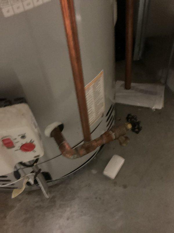 Responded to active plumbing leak in 30-year-old residential property causing visible water damage to interior drywall and ceiling. Upon arrival, confirmed ongoing leak had been present for several months and was localized to one area of the home. Conducted thorough investigation to identify leak source, tracing plumbing lines from affected ceiling area to basement mechanical room. 

Documented existing damage with photographs showing compromised ceiling with exposed opening and water-stained materials. Protected work area with plastic sheeting to prevent further damage during diagnostic and repair process. Inspected basement plumbing infrastructure, focusing on copper supply lines, water heater connections, and associated piping systems. Identified oxidation and discoloration on copper piping near water heater, indicating potential leak point at aged pipe joints or fittings.

Assessed integrity of plumbing connections, valves, and horizontal pipe runs servicing upper floor where ceili