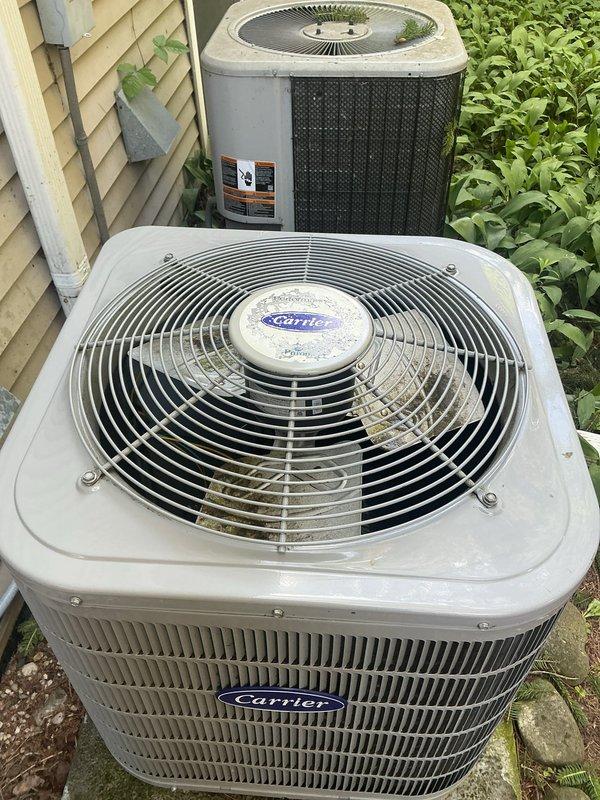 Completed annual cooling maintenance on 4-year-old Carrier model WT 12-2030 condenser unit. Performed comprehensive inspection of outdoor unit, noting moderate weathering and dirt accumulation on housing consistent with age and outdoor exposure. Observed algae and mildew growth on lower unit sections and concrete pad, indicating moisture exposure. Cleaned condenser coils and fan assembly, removed debris from base area, and verified proper airflow through louver vents. Tested fan motor operation, checked refrigerant levels, and confirmed electrical connections secure. Unit operational and cooling efficiently upon completion of tune-up service.