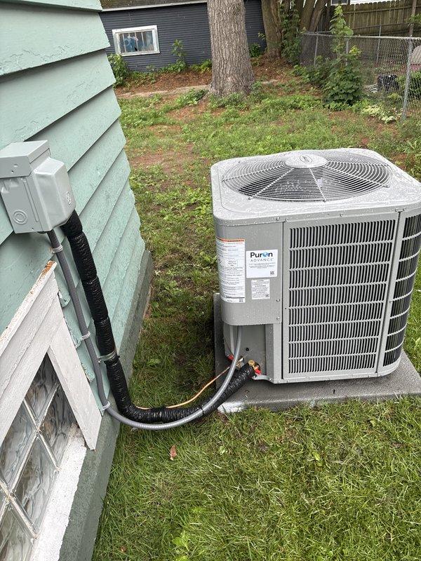 Completed full residential HVAC system installation including new Carrier furnace and Puron air conditioning condenser unit. Furnace installed in basement utility area with proper ductwork connections, ventilation components, and electrical conduit routing. Outdoor AC condenser positioned on level concrete pad in backyard with refrigerant lines and electrical disconnect box properly mounted to exterior wall. All components secured, labeled, and connected per manufacturer specifications.