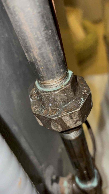 Responded to gas leak call following new AC unit installation. Upon inspection, identified corroded brass union fitting on gas line connection showing significant oxidation and aged threading. Documented deteriorated pipe coupling with photographic evidence showing greenish-white patina on brass components and compromised threaded connections between galvanized and black iron pipe sections. Addressed leak at union fitting to ensure safe gas system operation.